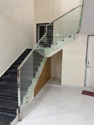 Professional railing installation team installing glass panels on balcony